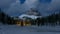 Mountain winter landscape at night, frozen lake and trees illuminated by moonlight and car in the valley, Tre Cime di Lavaredo, I