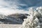 Mountain winter landscape. The sun is shining. Snow-covered valley. Landscape through the trees.