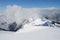 Mountain winter slope in clouds.