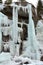 Mountaineer climbs an icefall in Alps of Piedmont, Italy