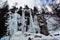 Mountaineer climbs an icefall in Alps of Piedmont, Italy