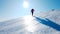 Mountaineer climbs a snowy mountain over blue clear sky. Winter