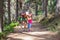 Mountaineer little child laughing and talking to woman on a footpath in forest