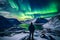 The mountaineer looks admiringly at the northern lights or Aurora phenomenon.