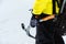 A mountaineer man holds an ice ax high in the mountains covered with snow. Close-up from behind. outdoor extreme outdoor