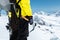 A mountaineer man holds an ice ax high in the mountains covered with snow. Close-up from behind. outdoor extreme outdoor