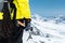 A mountaineer man holds an ice ax high in the mountains covered with snow. Close-up from behind. outdoor extreme outdoor