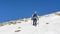 Mountaineer returning down the snow slope after finishing climbing with Quark ice axes