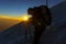 mountaineer silhouette at sunrise with ice ax in hand