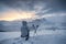 Mountaineer sitting with trekking pole in frosty weather on snow