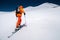 A mountaineer skier with a backpack, an ice ax, skis and poles, ascend on a ski tour to Mount Elbrus. Backcountry and