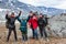 Mountaineers cheering and greeting with hands up, group of Caucasian hikers from one family hiking with backpacks in mountains