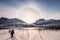 Mountaineers trekking on snow valley with sun halo in winter