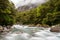 Mountainous Monkey creek flowing through impressive landscape next to Milford Sound highway, New Zealand