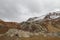 Mountains in autumn with brown and reddish grass under cloudy sky