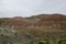 Mountains of clay rock. With red layers of rock rich in iron and ore, against a cloudy sky