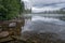 Mountains and clouds reflect in water surface of Pyramid Lake in Canadian Rockies. Misty, moody, rainy evening in Jasper National