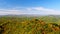 Mountains with colorful trees in autumn, blue sky and white clouds background, panning shot