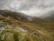 Mountains in Connemara, county Galway, Stone patches in grass land, Cloudy sky. Nobody