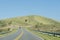 Mountains of Cordoba, Argentina: road, a car, grassy hill and cloudless sky