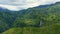 Mountains covered with jungle and a waterfall in the distance, aerial view.