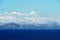 Mountains covered with snow in Aleutian Islands as a part of island chain in Alaska observed form vessel sailing over Pacific.