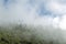 Mountains covered with white fluffy clouds with copy space