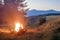 Mountains at evening with a bonfire with sparkles in front