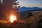 Mountains at evening with a bonfire with sparkles in front