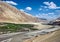 Mountains and flowing Shyok river with white clouds in blue sky background on way to Diskit in Nubra valley, Leh