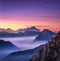 Mountains in fog at beautiful sunset in autumn in Dolomites