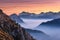 Mountains in fog at beautiful sunset in autumn. Dolomites, Italy