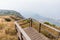 Mountains with golden grass and fog with the wooden observation deck along the way to Kew Mae Pan in Chiang Mai, Thailand