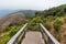 Mountains with golden grass and fog with the wooden observation deck along the way to Kew Mae Pan in Chiang Mai, Thailand