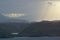 Mountains and lake with cloudy sky and sunray