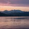 Mountains provide stunning backdrop to serene sunset over water