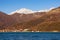 Mountains by the sea, winter Mediterranean landscape on sunny day. Montenegro, Bay of Kotor. View of snow-capped mountain of Orjen