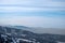 Mountains with smog rising from town. Visible border of clean and dirty air.