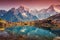 Mountains with snow covered peaks, red sky reflected in lake