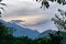 mountains and sunset sky view through tree leaves