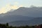 Mountains of the Trans-Ili Alatau in the morning haze and fog in the morning over the roofs of houses on a hillside