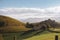 Mountains valley with house and road. Pyrenees autumn landscape. Scenic meadows and agricultural fields in hills valley.