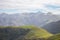 Mountains valley with scenic cloudscape. Pyrenees autumn landscape. Scenic meadows and agricultural fields in hills valley.