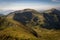 Mountainside with green grass, valley and peaks