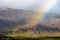 Mountainside with low clouds, sunshine and a rainbow