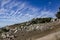 The mountainside is strewn with stones and in the background incredibly beautiful clouds