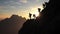 mountaintop climbers\\\' silhouettes symbolize power of teamwork and cooperation