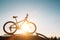 Mounted mountain bicycle silhouette on the car roof with evening sun light rays background. Safe sport items transportation using