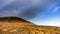 Mourn Wall on the bank of Slieve Donard mountain with blue sky, white clouds and sunlight