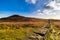 Mourn Wall on the bank of Slieve Donard mountain with blue sky, white clouds and sunlight